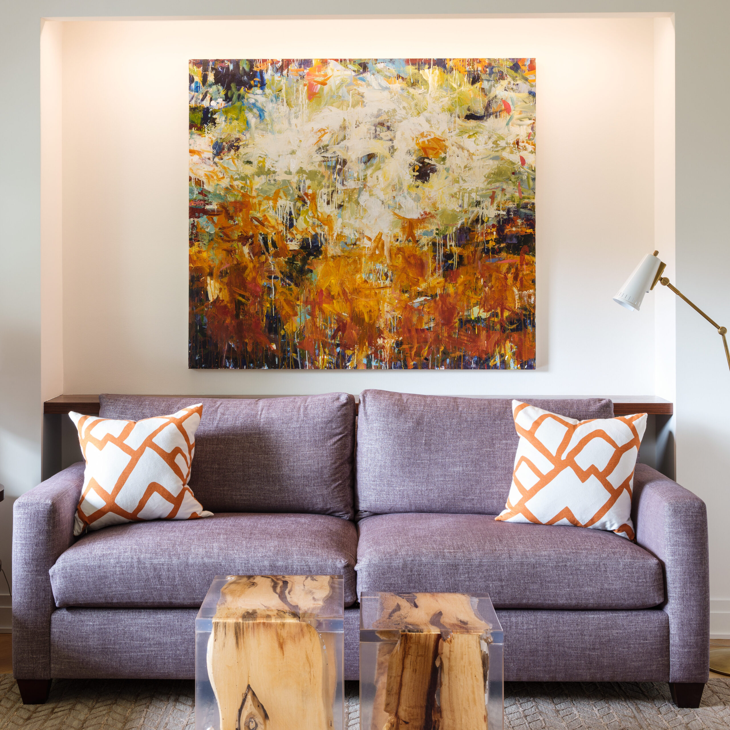 Purple sofa with orange and white pillows