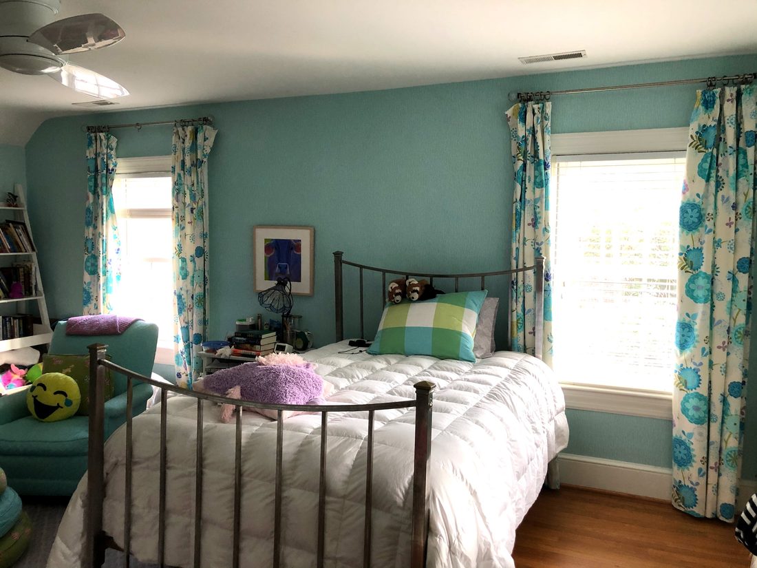 Teenage girl's bedroom with aqua blue walls and flowered curtains