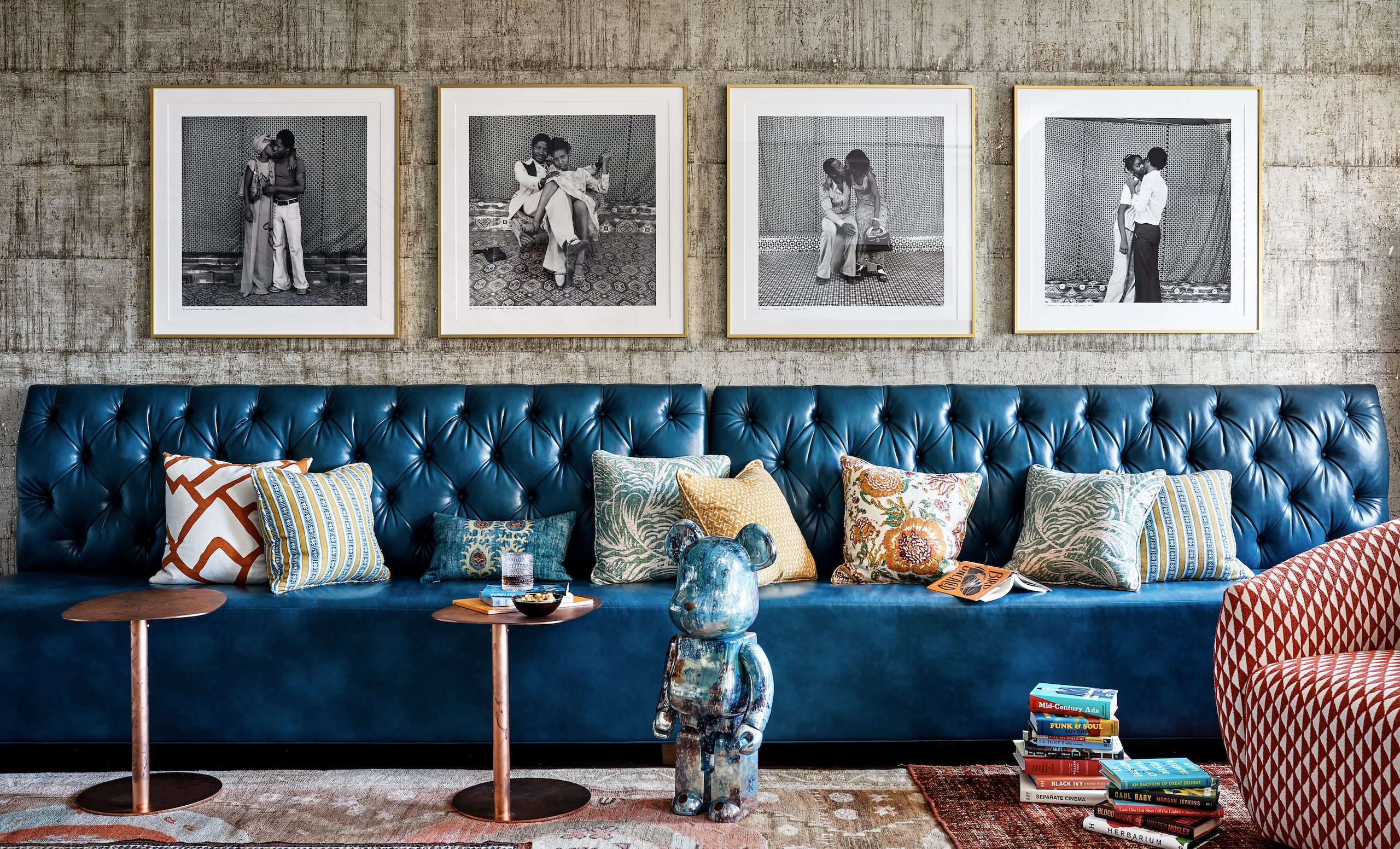 Various pillows in different shapes and fabrics on blue leather sofa