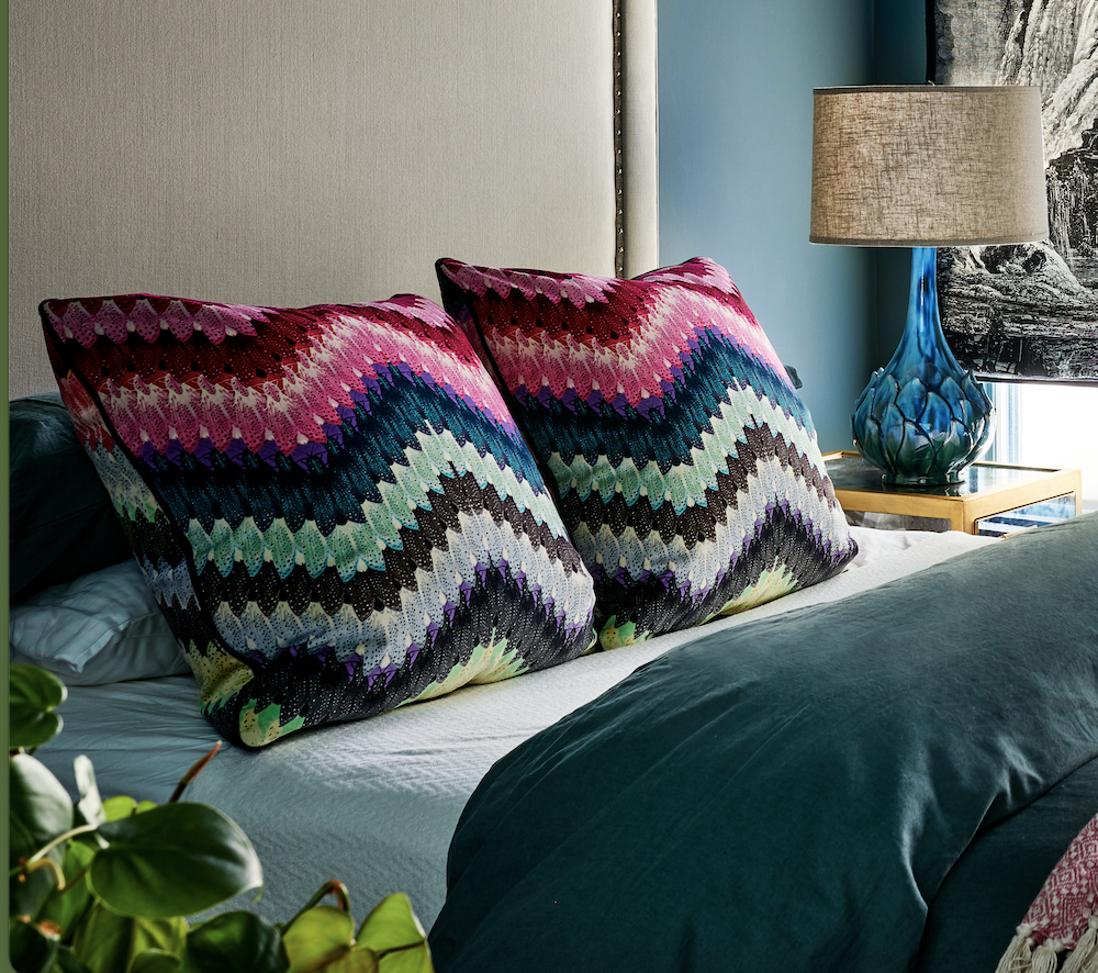 Colorful zig-zag accent pillows on a bed