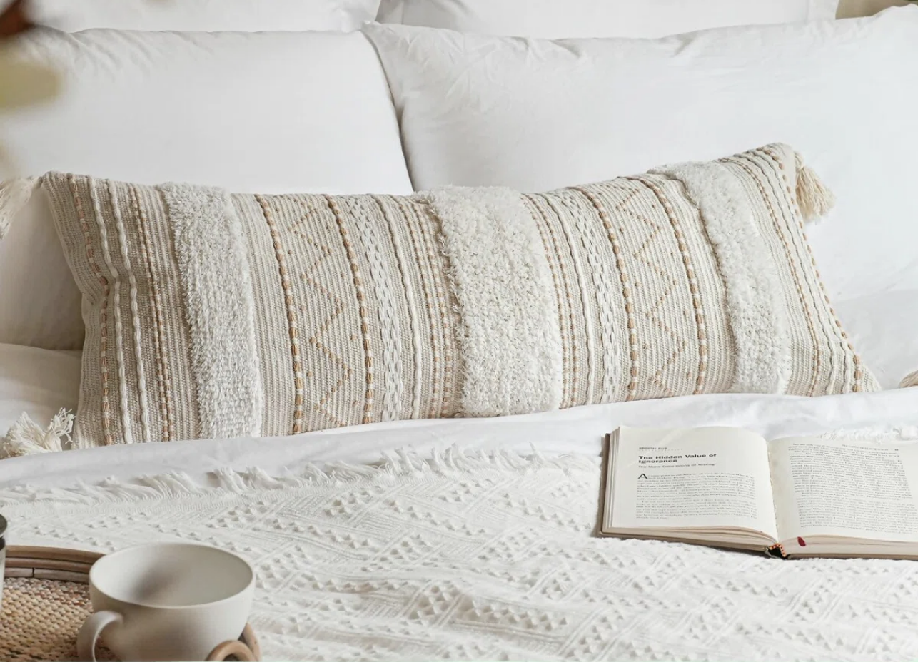 Neutral textured lumbar pillow in front of white pillows