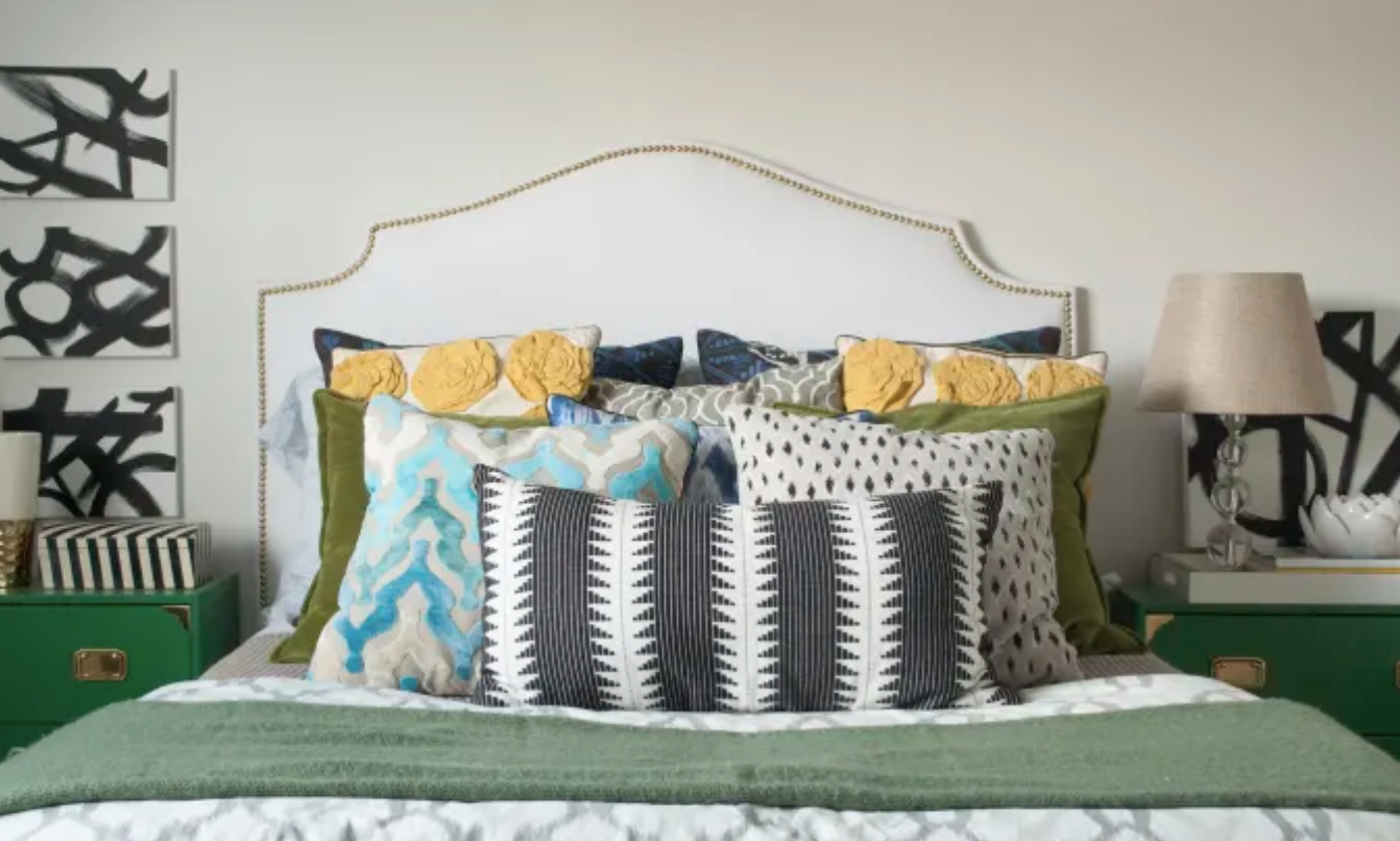Bed with many rows of unmatching pillows